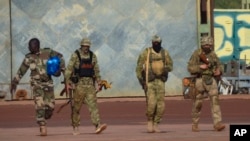 This undated photo provided by the French military shows three Russian mercenaries in northern Mali. Mali and its neighbors have long battled an Islamic extremist insurgency. Ruling juntas have turned to Russia's mercenary units for security assistance.