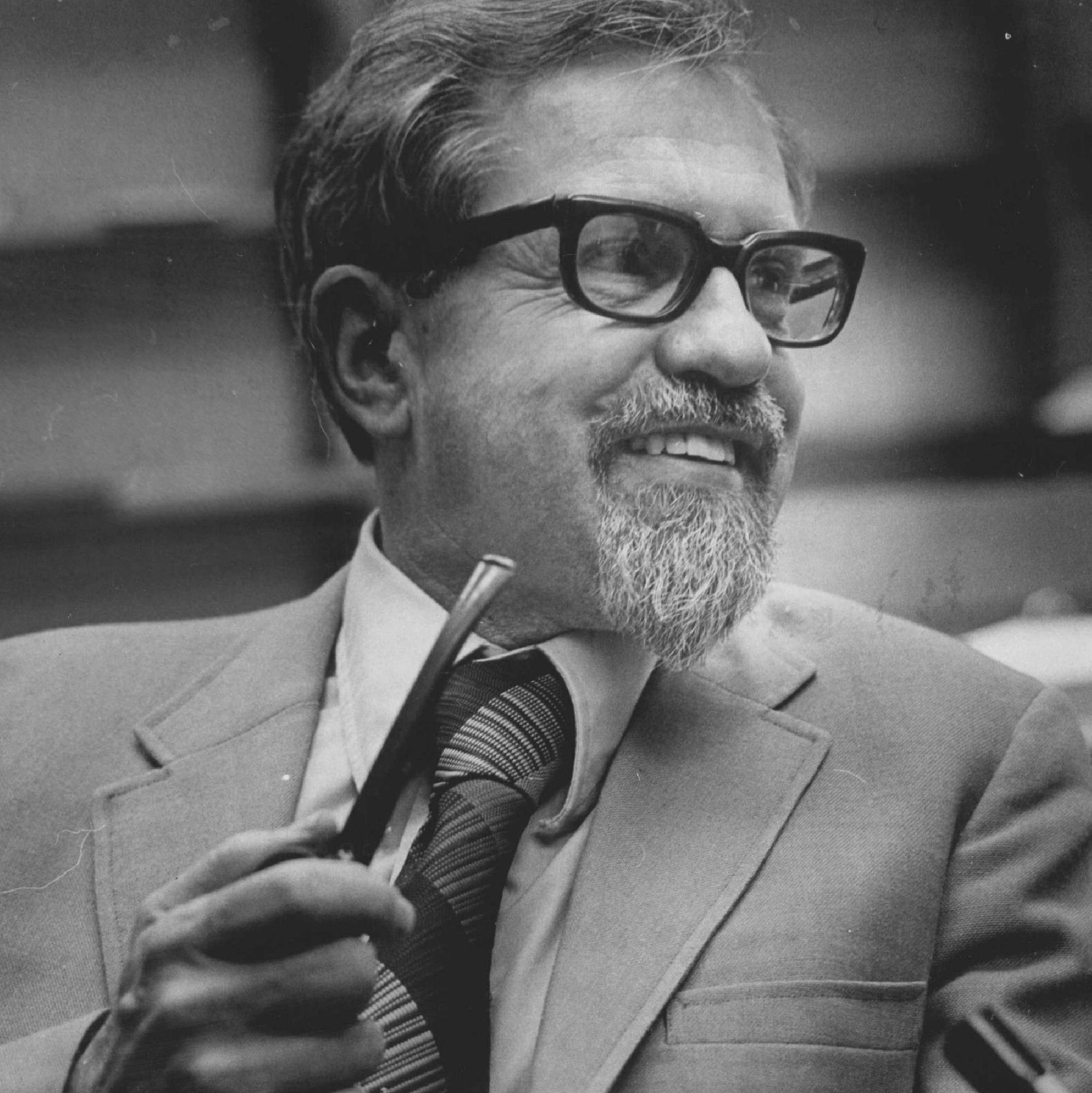 j allen hynek smiling and holding pipe