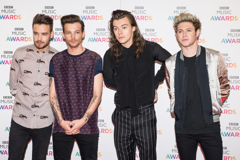 Liam Payne, Louis Tomlinson, Harry Styles, and Niall Horan at the BBC Music Awards. They are wearing casual and semi-formal outfits