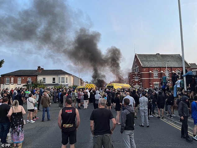 Smoke is seen billowing from a police van which was set ablaze during protests in Southport on Tuesday