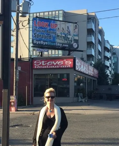 Suzanne Maher Suzanne Maher in front of a Bye Bye Blue Sky billboard in Toronto