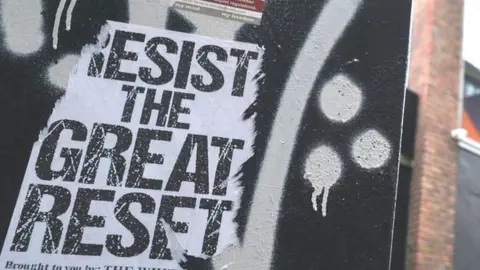 Getty Images A poster 'Resist The Great Reset' seen next to a Google building GRCQ1 in Dublin's Grand Canal area during Level 5 Covid-19 lockdown. On Tuesday, March 2, 2021