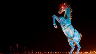 A statue of a blue rearing stallion in front of the Denver Airport