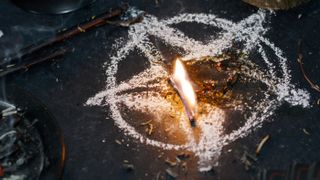 A pentagram drawn in salt on the ground with burning herbs in the middle