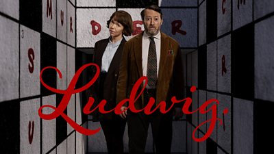 Key art for Ludwig featuring David Mitchell and Anna Maxwell Martin. Walls beside the characters are covered in large crossword puzzles. Red ink has been used to complete one crossword answer behind the characters, spelling out ‘murder’. 