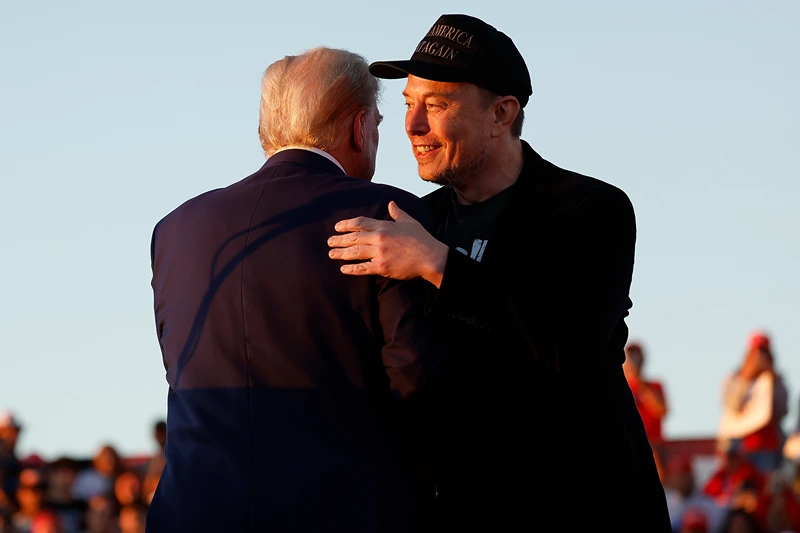 Elon Musk embraces Republican presidential nominee, former President Donald Trump during a campaign rally at the Butler Farm Show fairgrounds on October 05, 2024 in Butler, Pennsylvania. This is the first time that Trump has returned to Butler since he was injured during an attempted assassination on July 13. (Photo by Anna Moneymaker/Getty Images)