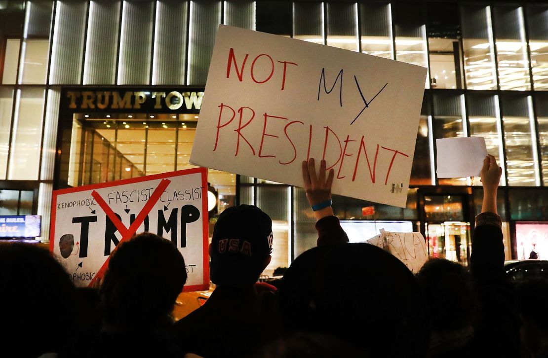 Dozens of anti-Donald Trump protesters stand in front of Trump Tower in New York on November 10, 2016, in the aftermath of Trump's win against Hillary Clinton in the 2016 election.