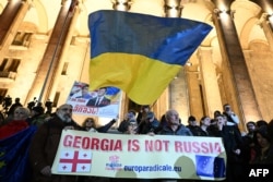 Georgian opposition supporters rally to protest results of the parliamentary elections that showed a win for the ruling Georgian Dream party, outside the parliament building in central Tbilisi, Oct. 28, 2024.