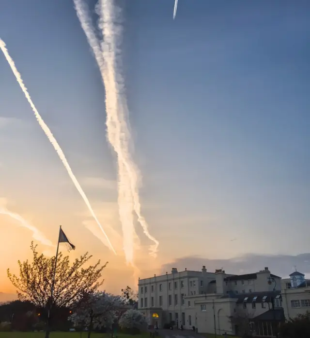 Aircraft vapour trails of scheduled services flying into Heathrow over the former BBC Monitoring building in Reading