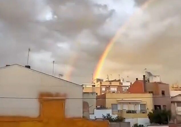 Conspiracy theorists spot 'UFOs' in sky over Spain and claim eerie footage of lights next to double rainbow was 'warning' of flooding disaster