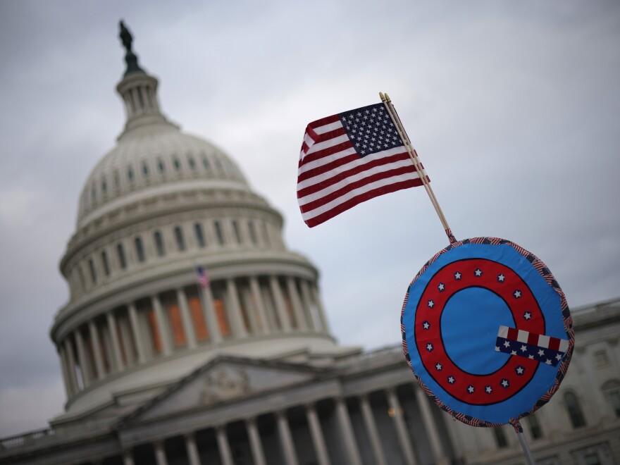 Supporters of then-President Donald Trump fly a U.S. flag together with a QAnon symbol as they gather outside the U.S. Capitol in Washington, D.C., on Jan. 6, 2021.