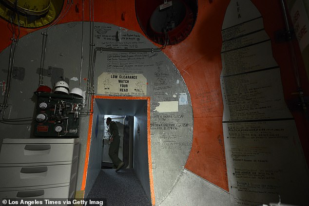 Above, a missile combat crew member at Captain Salas' old post - Malmstrom Air Force Base - prepares to close a three-foot thick door inside a nuclear launch control center 70-feet underground