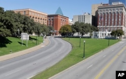 FILE - The former Texas School Book Depository building, left, now known as the Sixth Floor Museum, overlooks Dealey Plaza in Dallas. Lee Harvey Oswald fired from the building, killing President John F. Kennedy on Nov. 22, 1963.