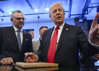 FILE - Republican presidential nominee former President Donald Trump signs autographs as Massad Boulos listens during a visit to The Great Commoner, Nov. 1, 2024, in Dearborn, Mich. (AP Photo/Julia Demaree Nikhinson, File)