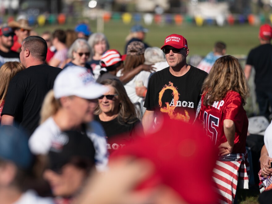 A man wearing a QAnon t-shirt walks through the crowd at a Trump rally on Sept. 25, 2021 in Perry, Ga. The nonprofit PRRI, which conducts polls on religion, found that 19% of Americans believe in the core theories associated with QAnon, up from 14% in 2021. The poll found the number rose to 32% among Republicans who support Trump.