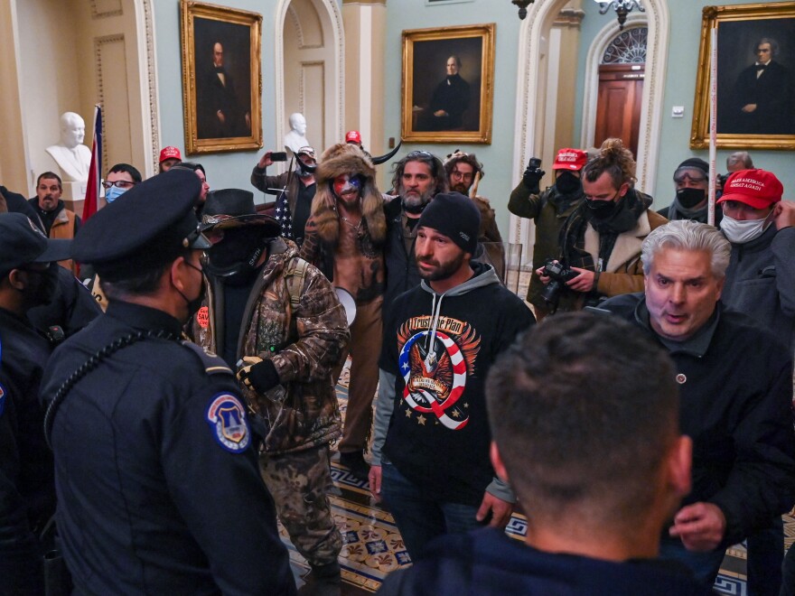 Douglas Jensen and other rioters speaking to U.S. Capitol Police in the U.S. Capitol on Jan. 6, 2021. Jensen later told the FBI he had worn the QAnon shirt and put himself at the front of the crowd because he "wanted Q to get the attention."