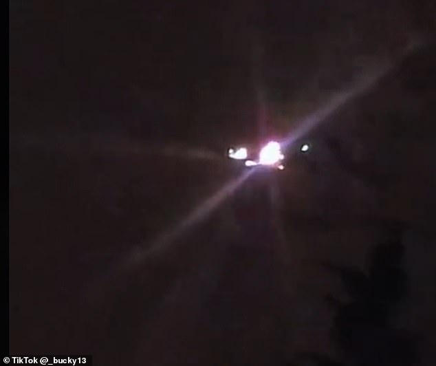 One UFO or drone in a recent Tik Tok video looks like it might have hovered stationary beyond the tree line, lit up with multiple lights that pulsed bright enough to produce a lens flare effect