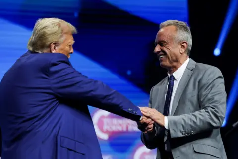 Reuters Robert F. Kennedy Jr. and Republican presidential nominee and former U.S. President Donald Trump greet each other at a campaign event.