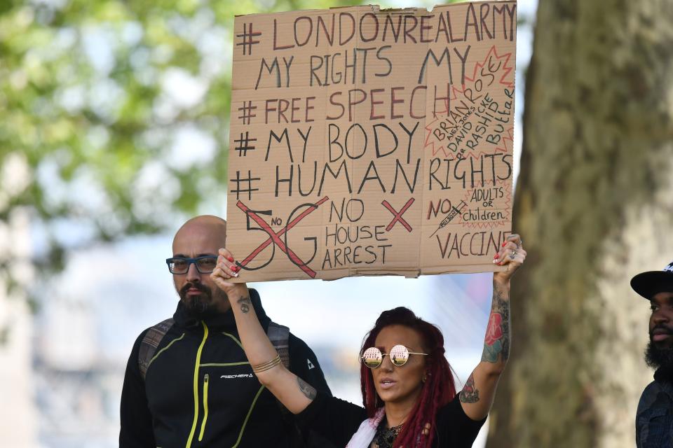 A protestor holds a placard outside New Scotland Yard 