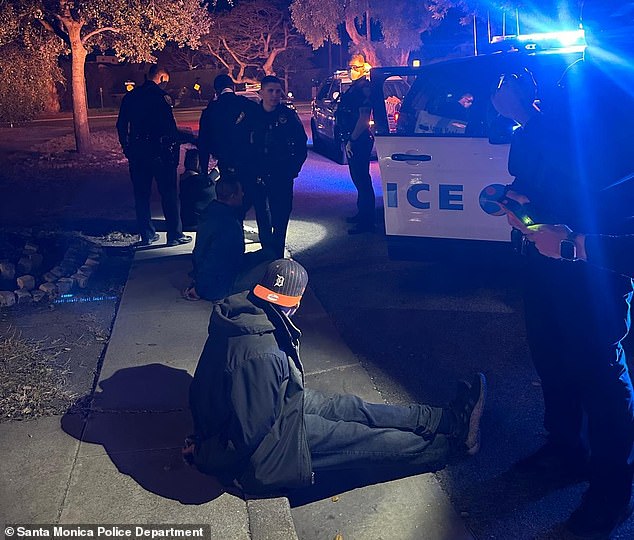 A looter sits on the footpath after being arrested by police