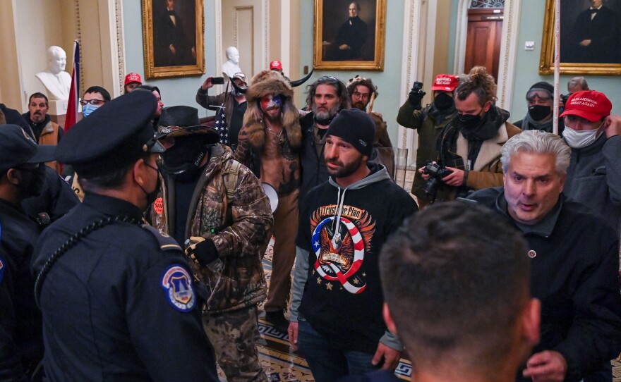 Douglas Jensen and other rioters speaking to U.S. Capitol Police in the U.S. Capitol on Jan. 6, 2021. Jensen later told the FBI he had worn the QAnon shirt and put himself at the front of the crowd because he "wanted Q to get the attention."